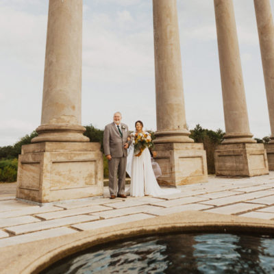 bride and groom pose amongst the capitol columns