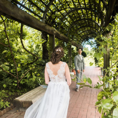bride and groom walking together in the national herb garden under the grape pergola