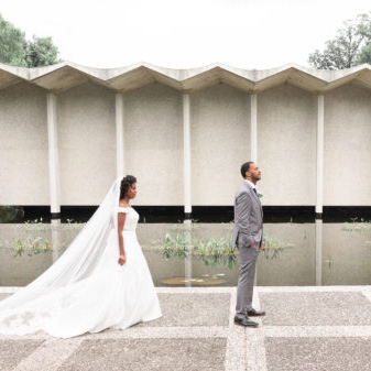bride and groom in front of the visitor center pond