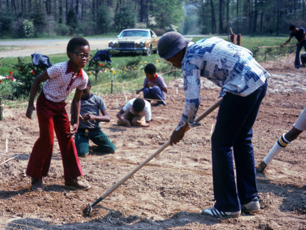 historic photo of students tilling soil in the washington youth garden