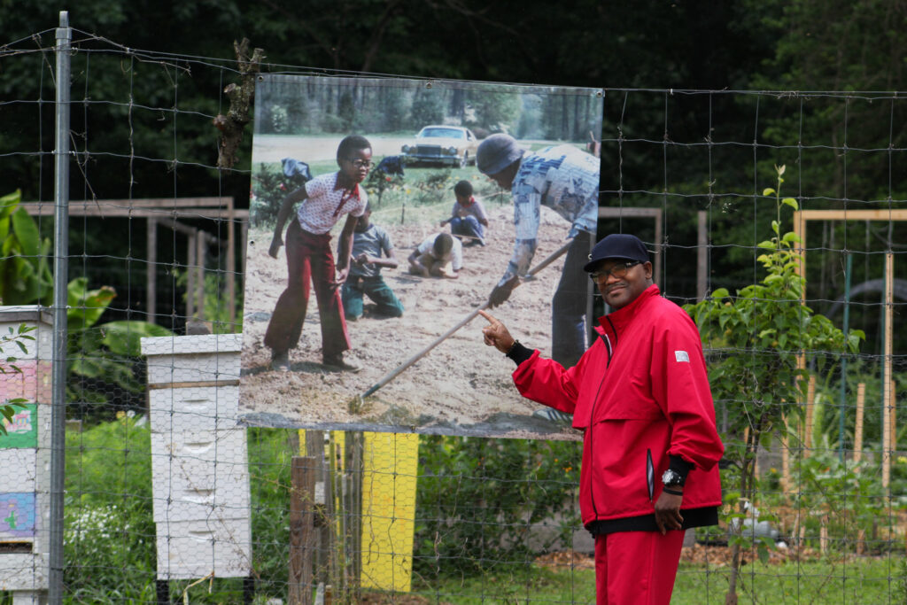 former washington youth garden participant poses in front of a photo of himself from the 1970s