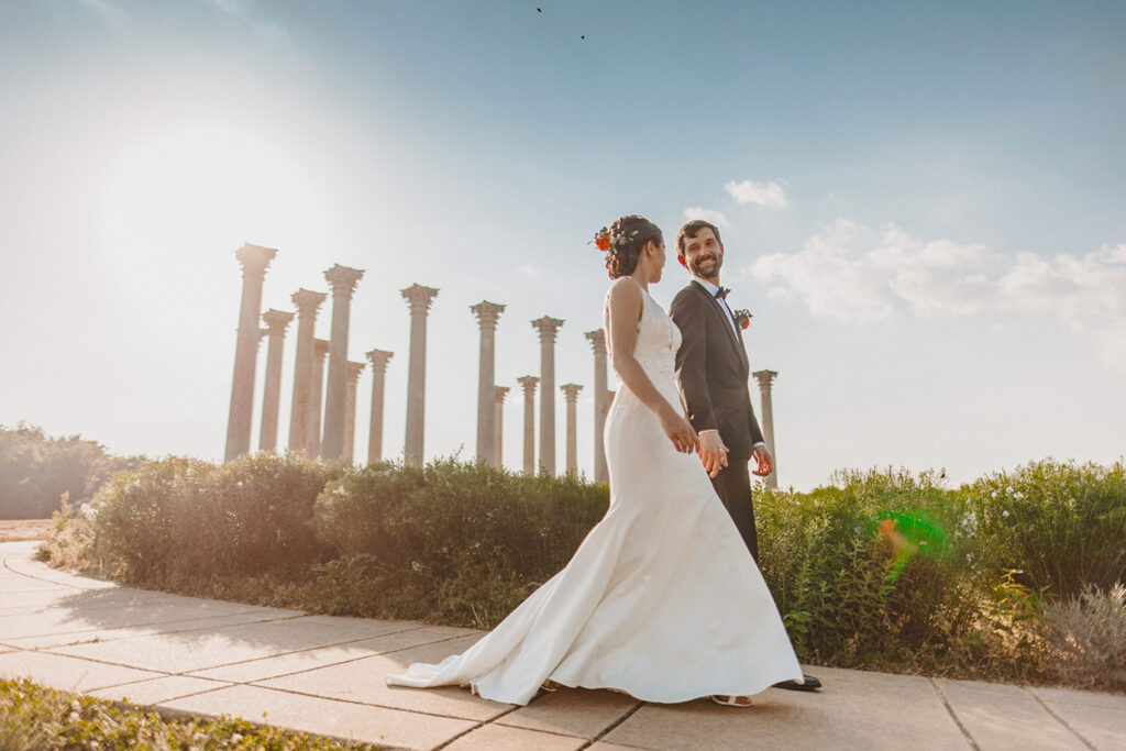 Bride and groom walking down from the capitol columns