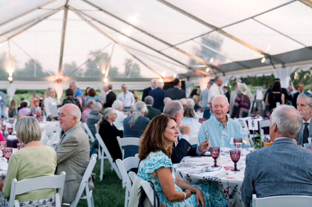 Dinner Under the Stars attendees in the tent preparing for dinner