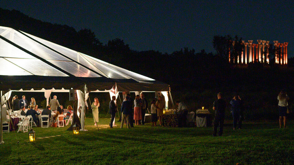 Dinner Under the Stars tent lit up at night with the capitol columns in the background