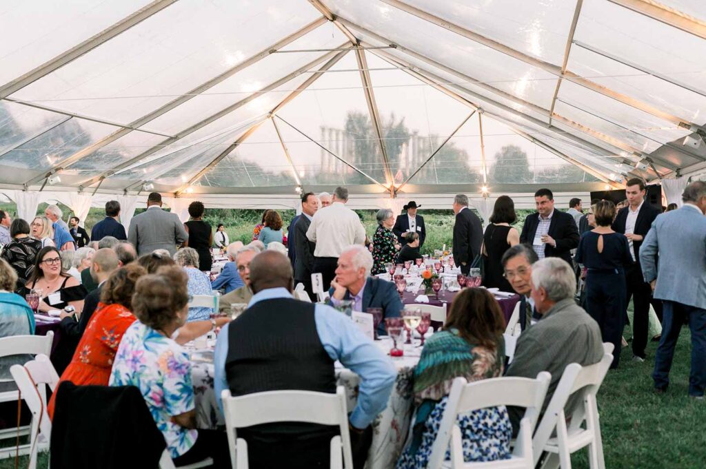 Dinner Under the Stars attendees under the tent getting ready for dinner