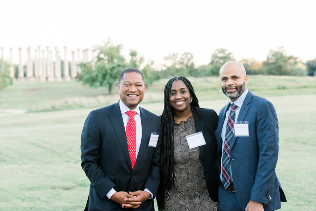 Dinner under the stars attendees stand in the meadow in front of the capitol columns