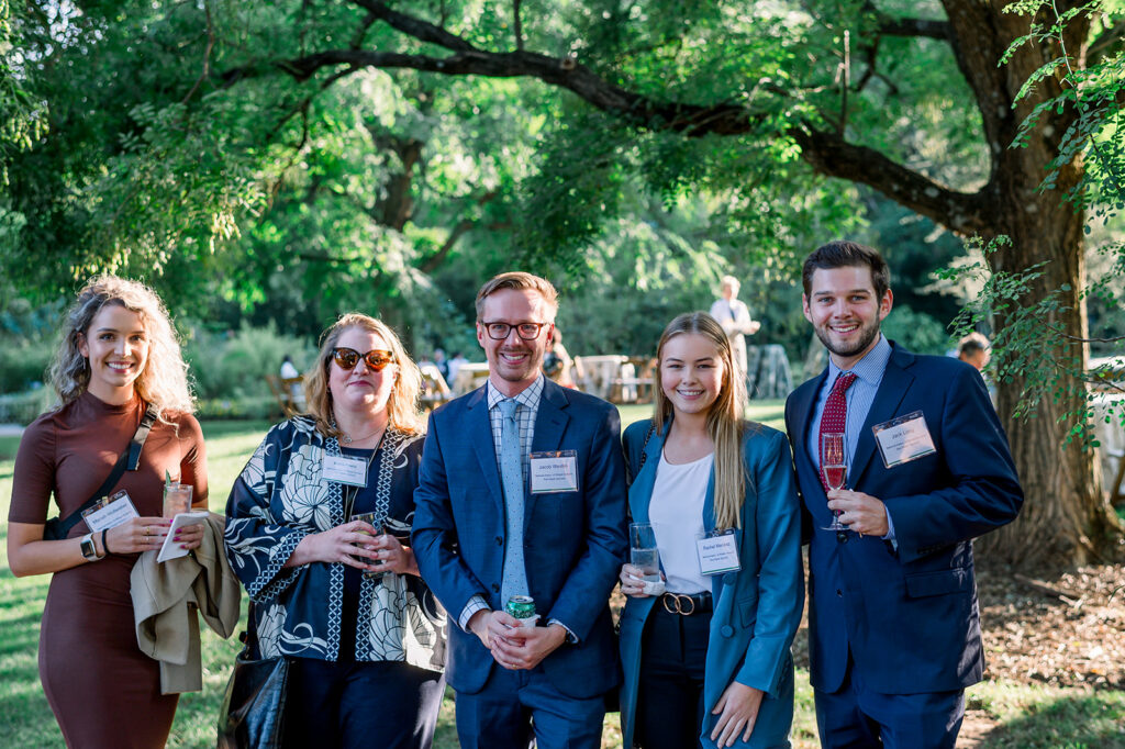 dinner under the stars attendees posing and smiling for the camera in the national herb garden