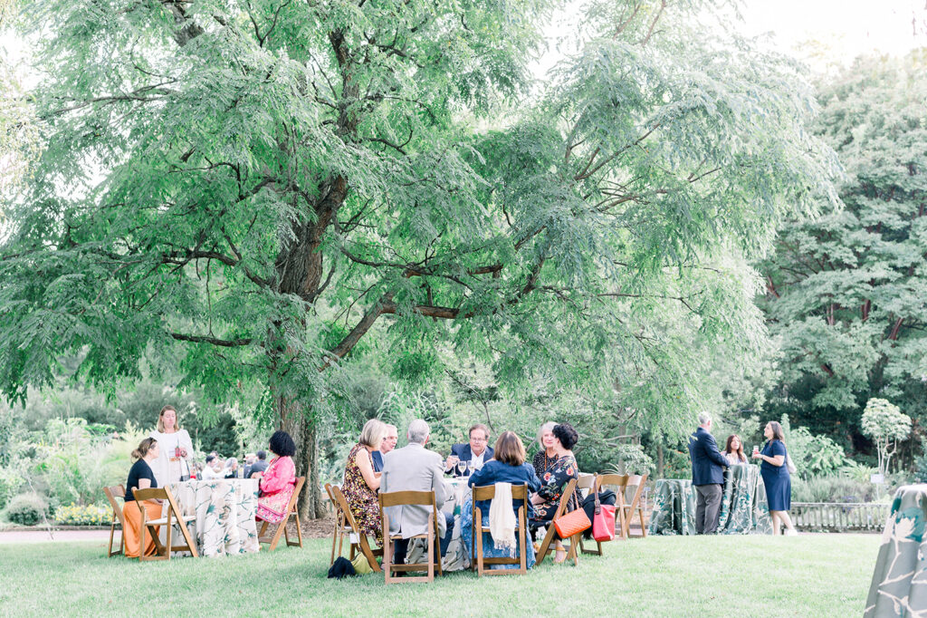 Dinner under the stars attendees sitting in the national herb garden during cocktail hour