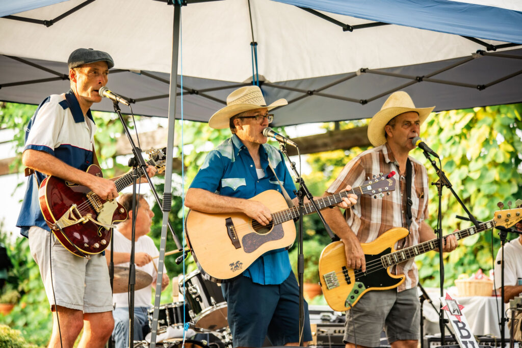 the three members of the buck forty nine band playing music in the meadow