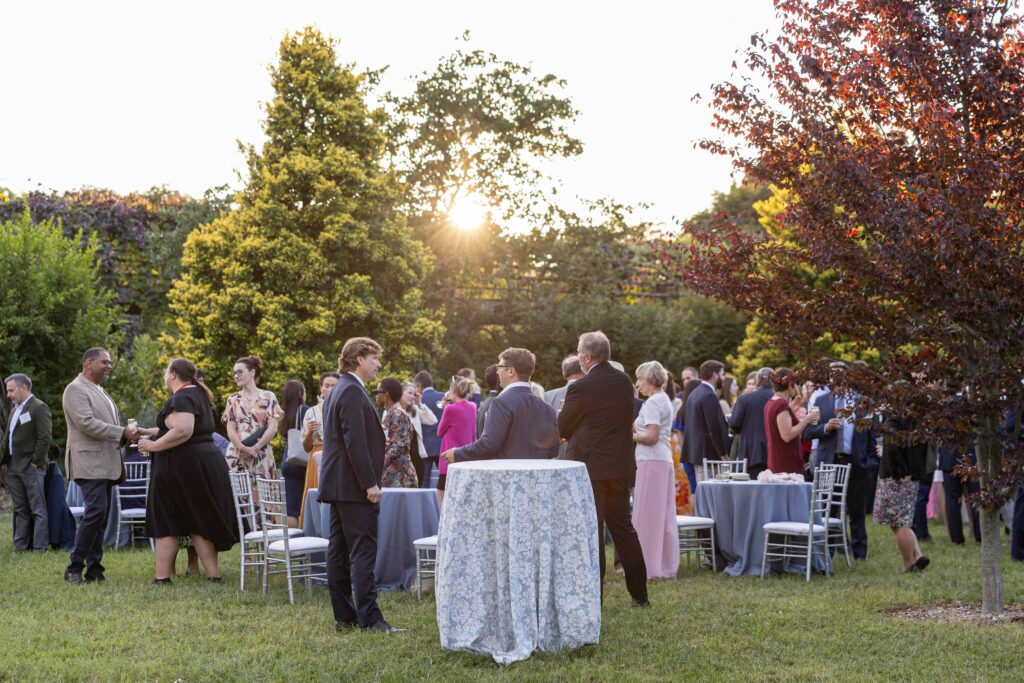 Dinner Under the Stars guests standing and talking during cocktail hour at sunset
