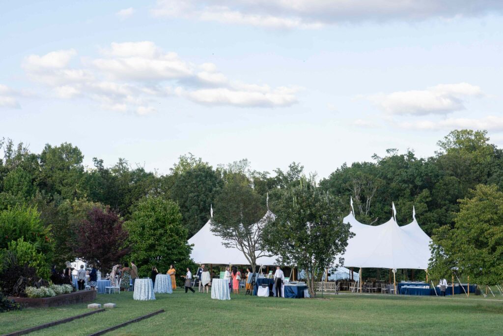Dinner Under the Stars event tent in the background, with cocktail tables in the foreground