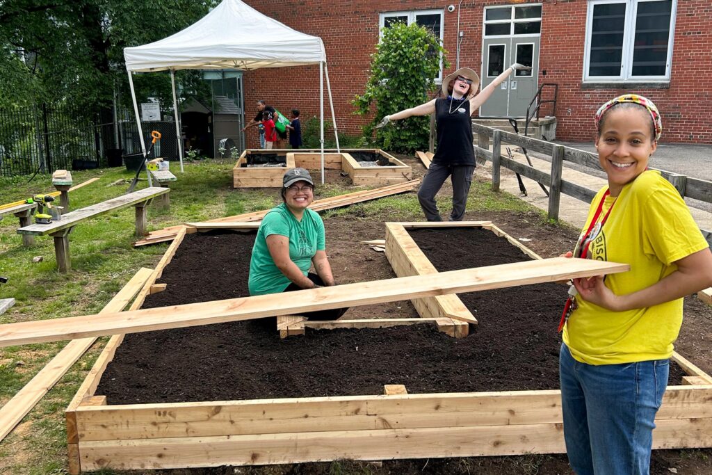 Hendley ES teacher and FONA staff build a raised bed in the school garden