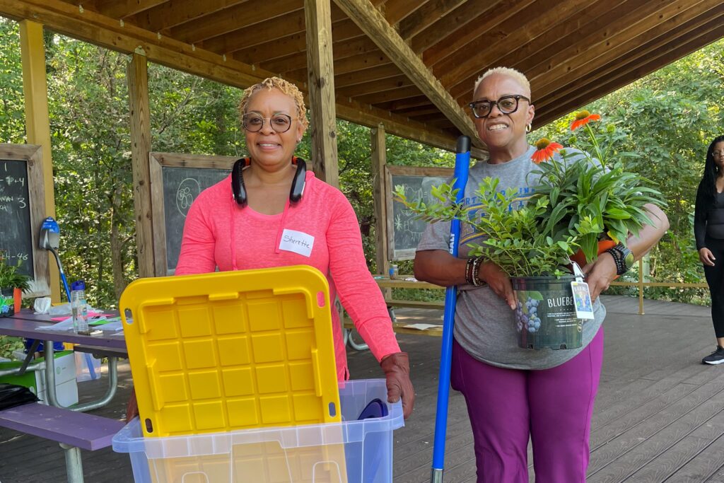 Two teachers at Fall into School Gardening event take supplies back to their school gardens
