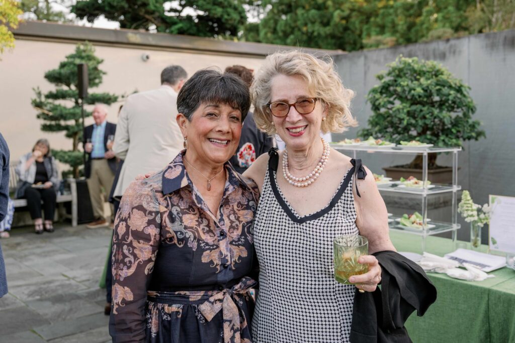 Guests at the 2026 spring soiree in the national bonsai and penjing museum, smiling at the camera and holding a drink