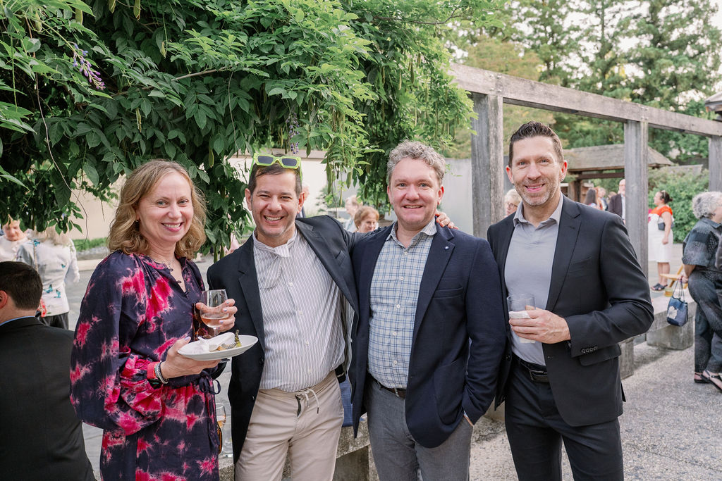 Guests at the 2026 spring soiree in the national bonsai and penjing museum, smiling at the camera and holding a drink