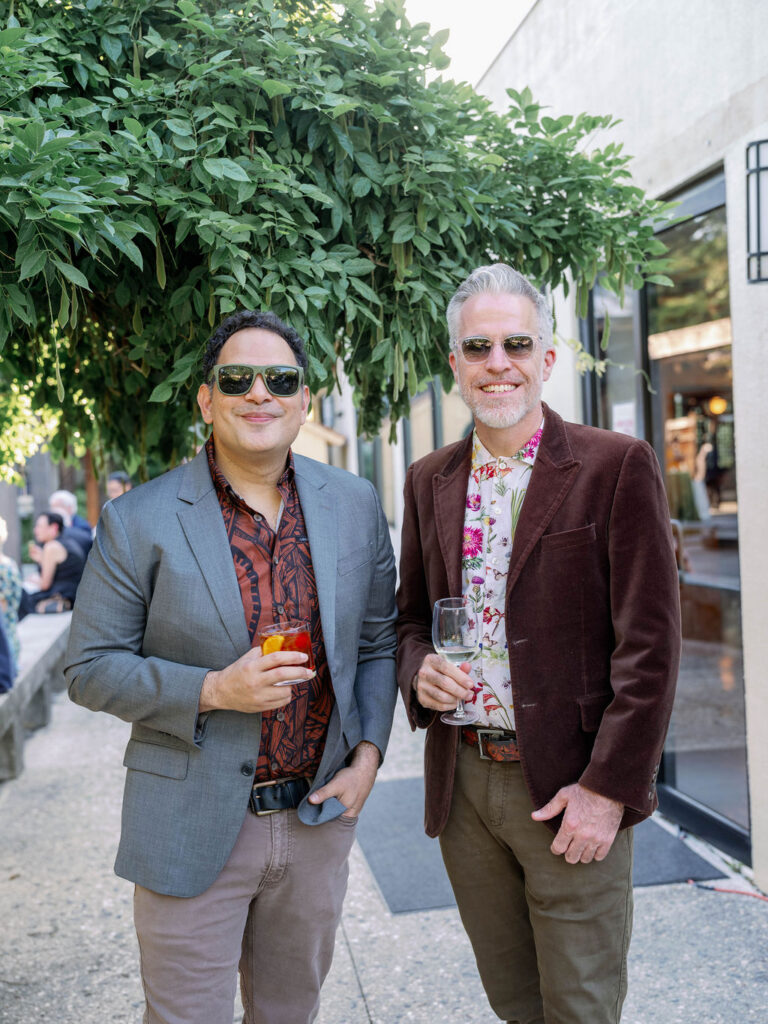 Guests at the 2026 spring soiree in the national bonsai and penjing museum, smiling at the camera and holding a drink